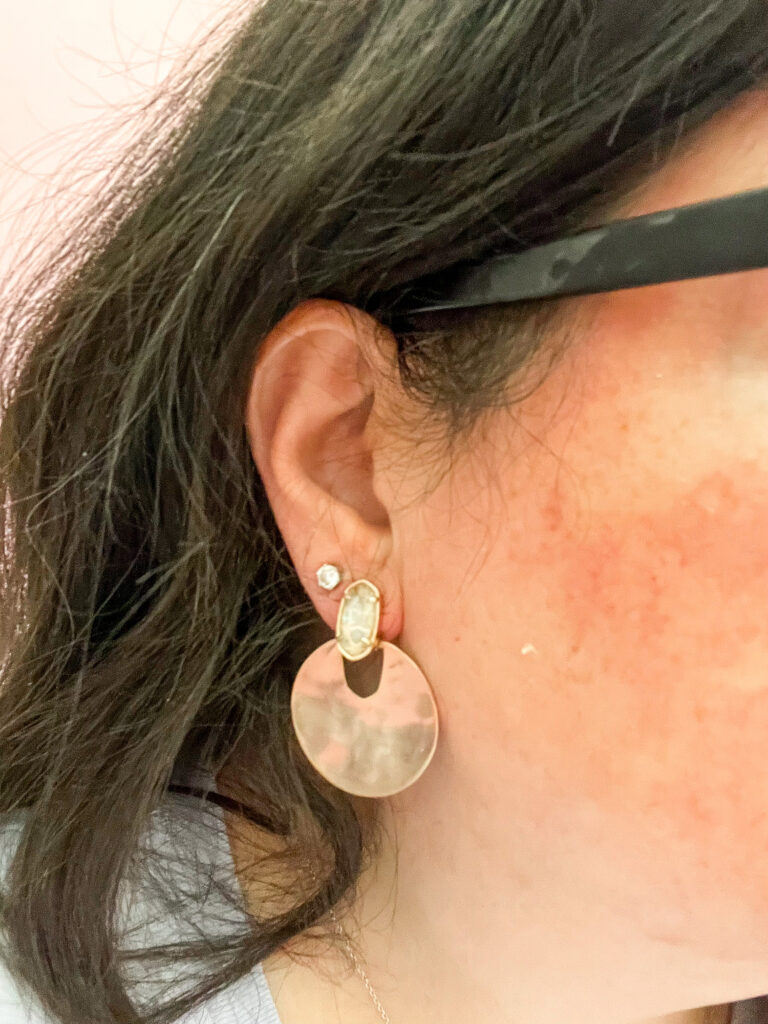 Gold Kendra Scott earrings.